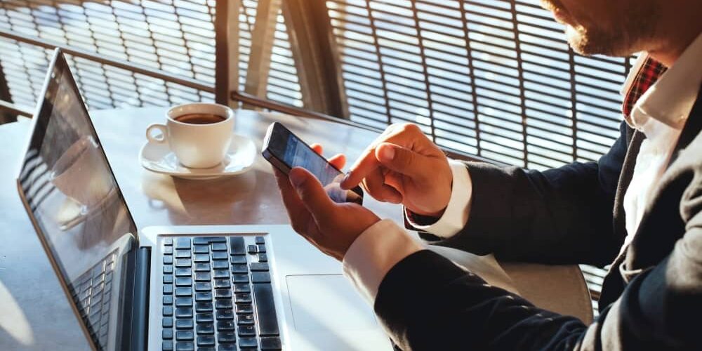 Businessman working, using laptop and smartphone.