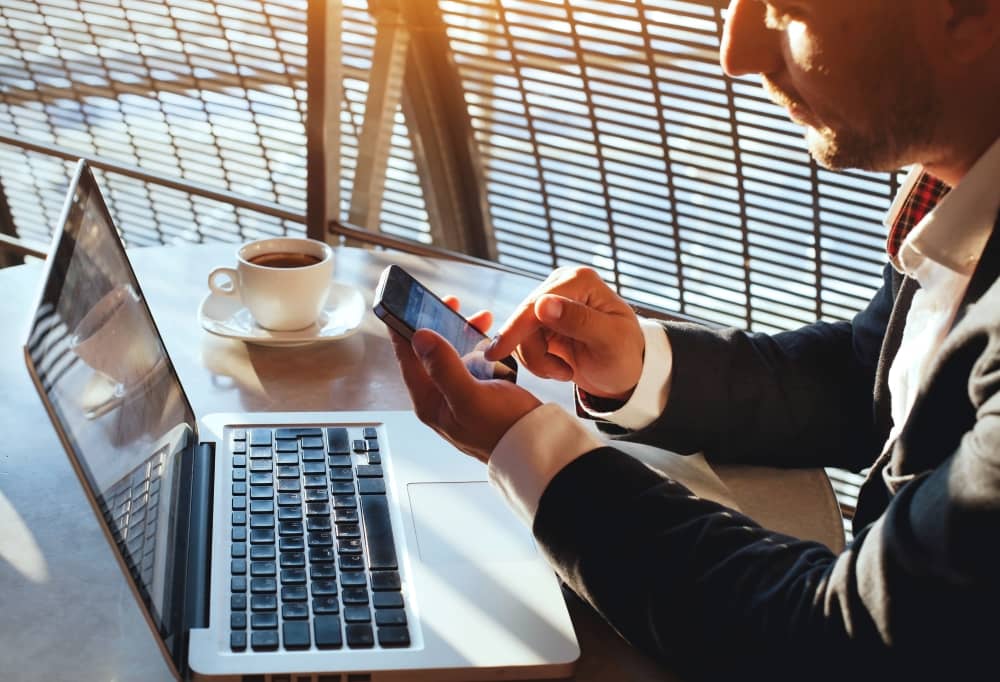 Businessman working, using laptop and smartphone.