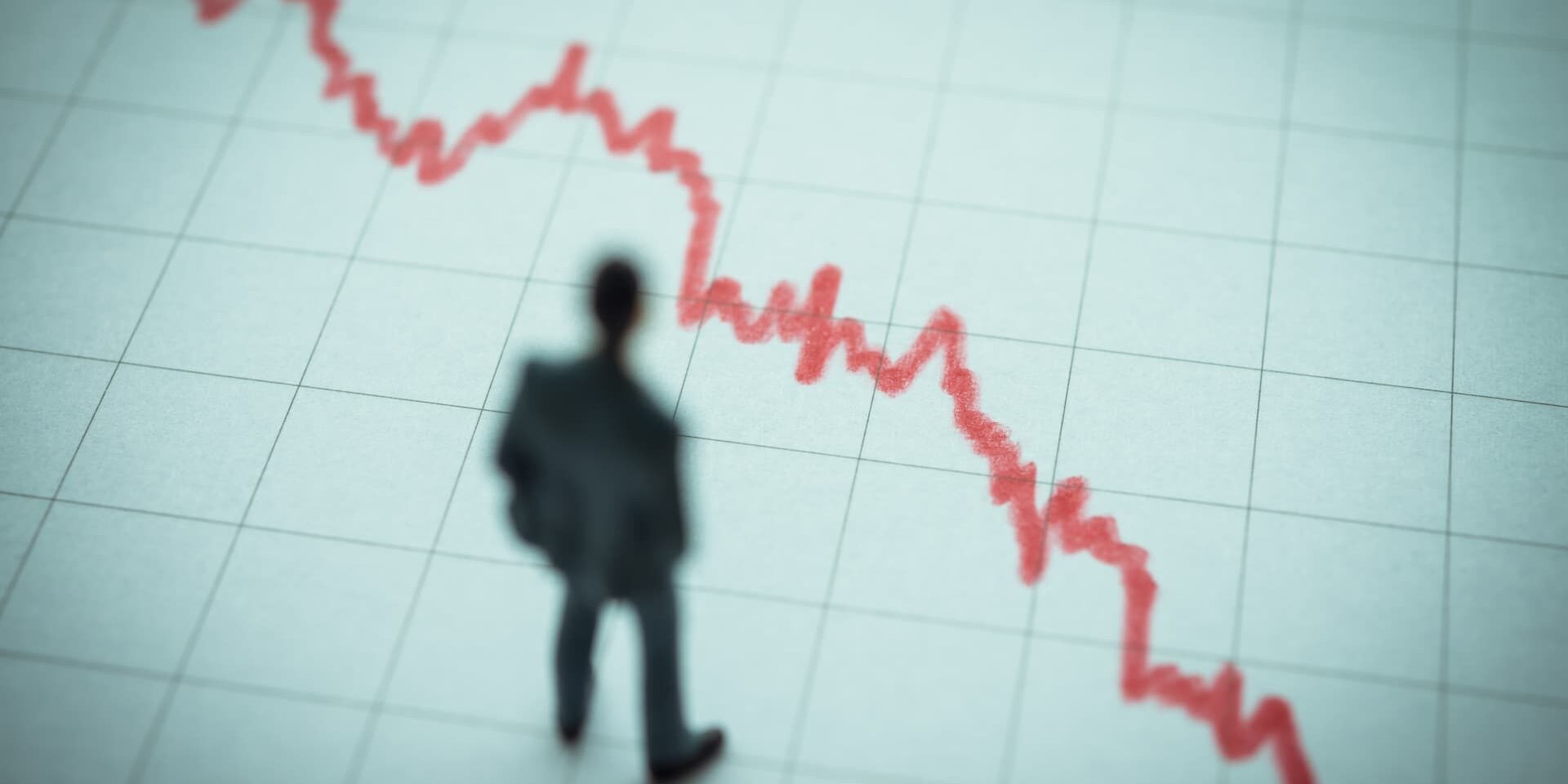 Business man looking at falling chart wondering what is insolvent trading