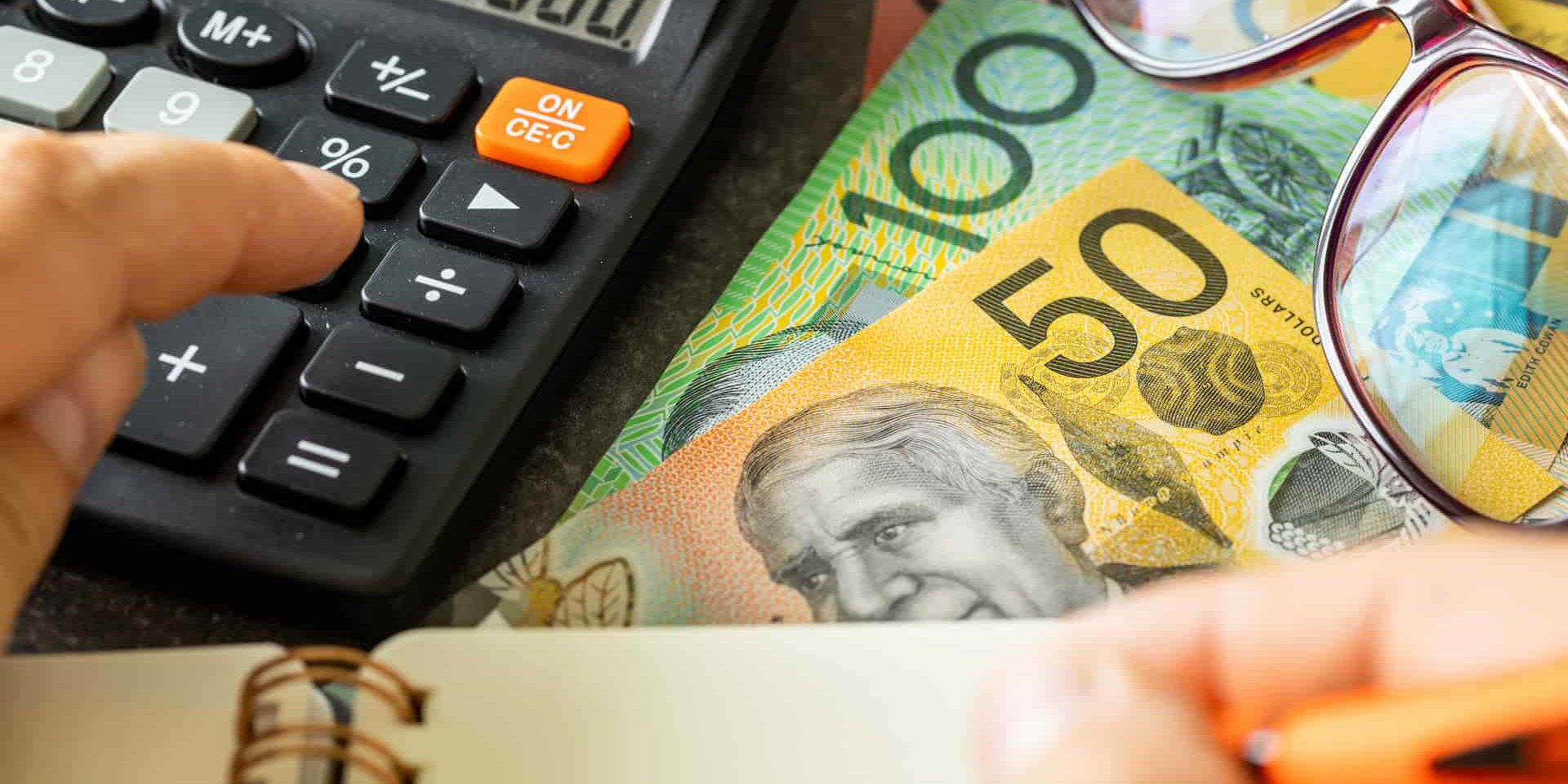 Calculator, notepad and money on table showing how to lodge a business tax return
