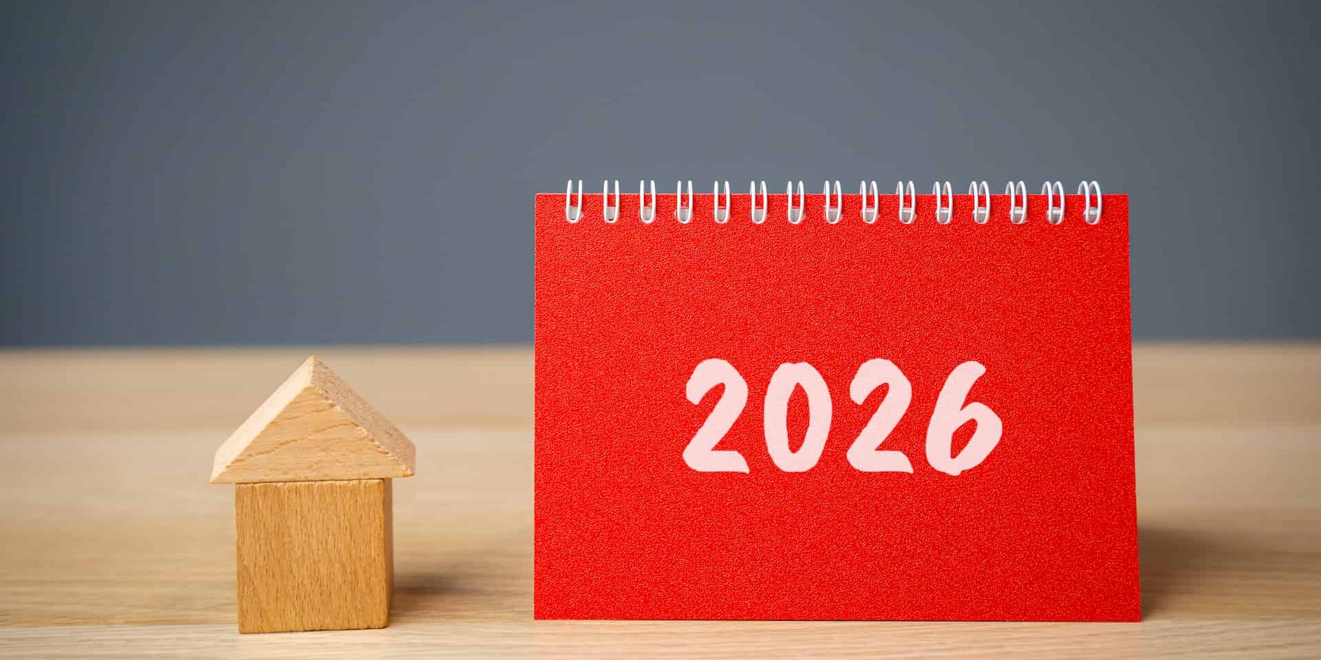 Small wooden house prop and red note book with '2026' labelled for tax and business strategy for 2026