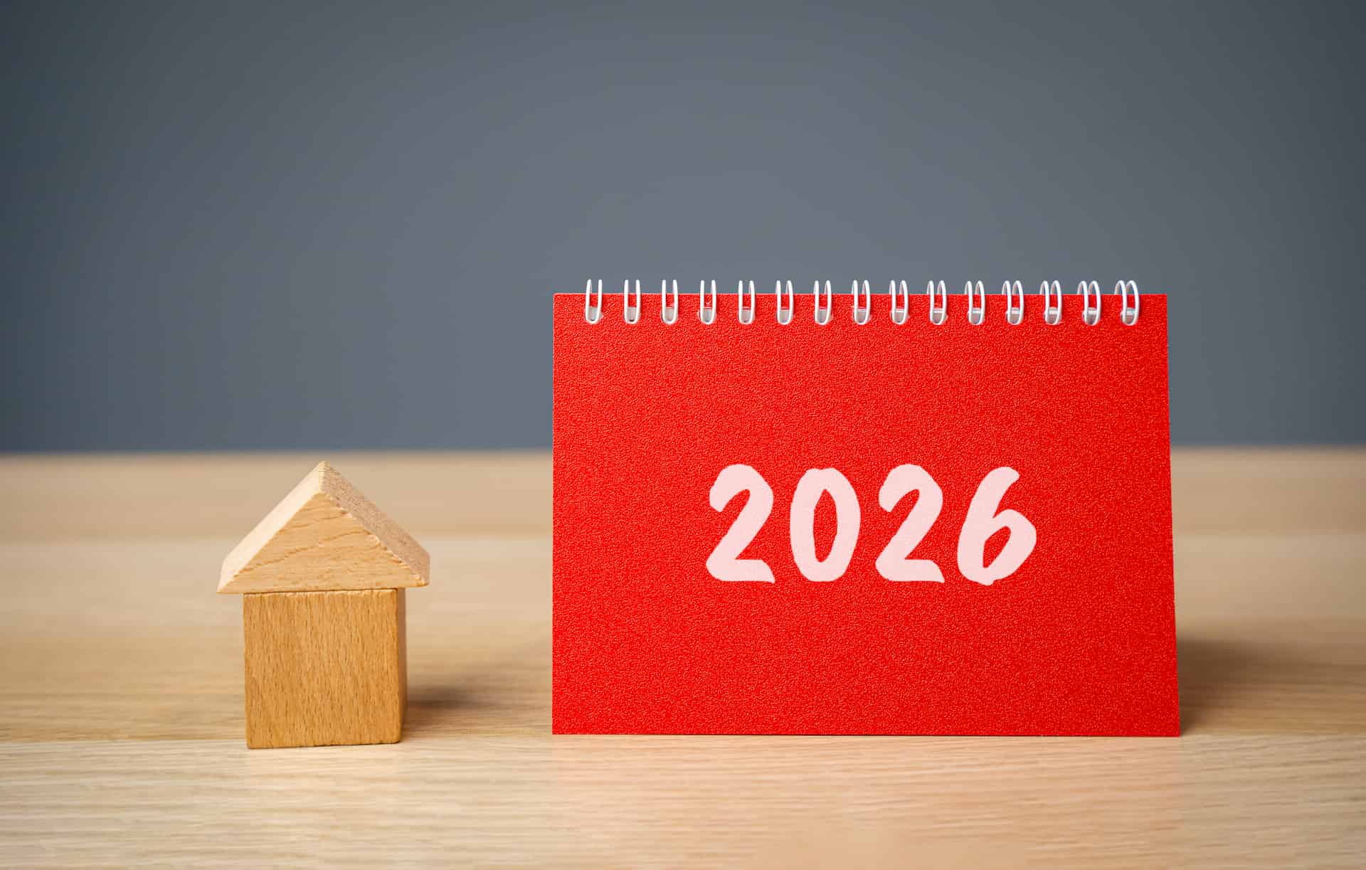 Small wooden house prop and red note book with '2026' labelled for tax and business strategy for 2026